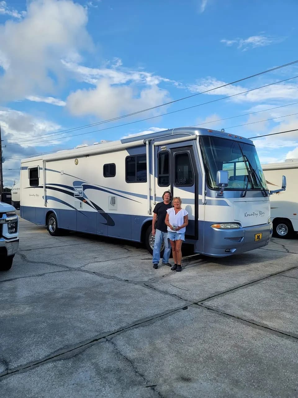 Couple standing at the door of their Newmar Kountry Star motorhome